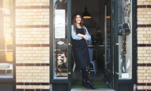 Young business woman leaning against doorway